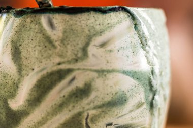 Closeup görünümü cam mutfak masasında içinde kaşık ile yeşil spirulina mamasının taze kefir probiotik içeceği boşalttı