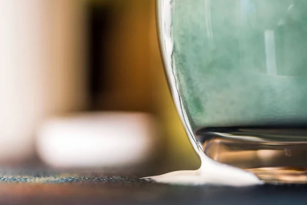 Вид крупным планом свежий кефир пробиотик напиток появился из прозрачного стекла, где он был смешан с зеленой спирулиной порошок на кухонном столе — стоковое фото