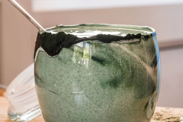 Mutfak masasının üzerinde yeşil spirulina tozu ile portre görünümü taze kefir probiotik içki açık cam içinde karışık