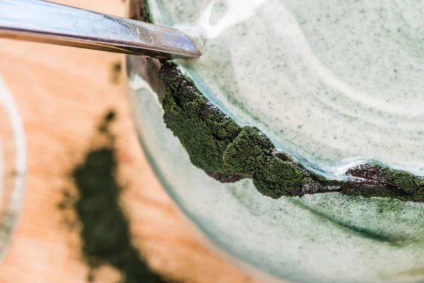 Mutfak masasının üzerinde yeşil spirulina tozu ile portre görünümü taze kefir probiotik içki açık cam içinde karışık