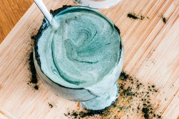 Mutfak masasının üzerinde yeşil spirulina tozu ile portre görünümü taze kefir probiotik içki açık cam içinde karışık