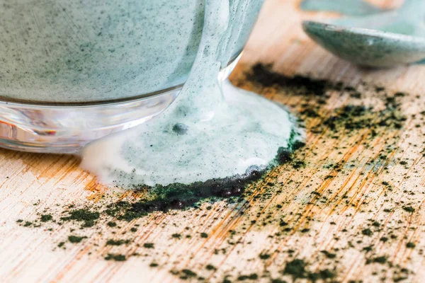Mutfak masasının üzerinde yeşil spirulina tozu ile portre görünümü taze kefir probiotik içki açık cam içinde karışık