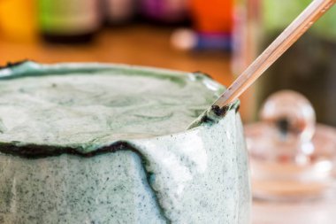 Mutfak masasının üzerinde yeşil spirulina tozu ile portre görünümü taze kefir probiotik içki açık cam içinde karışık