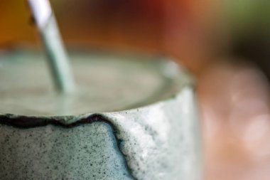 Mutfak masasının üzerinde yeşil spirulina tozu ile portre görünümü taze kefir probiotik içki açık cam içinde karışık