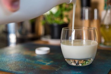 El yağan taze kefir probiotik suya beyaz şişe açık cam mutfak masasında