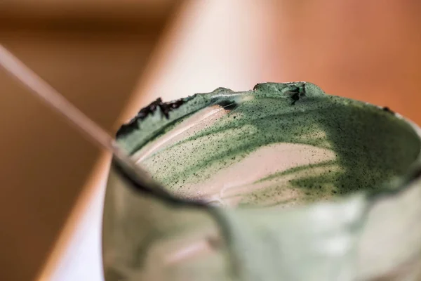 Вид крупным планом пустой стакан свежего кефира пробиотик напиток смешанный с зеленой спирулиной порошок с ложкой внутри на кухонный стол — стоковое фото