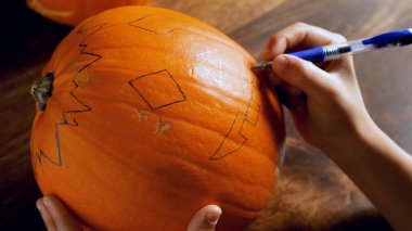 Oyma ve balkabağı Cadılar Bayramı için bir tablo üzerinde boya genç çocuk