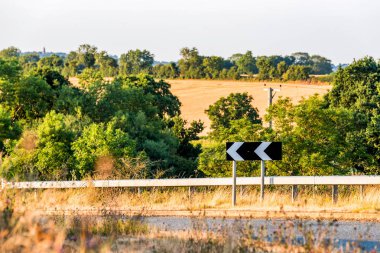 Kırsal kırsal peyzaj üzerinde İngiliz yolda keskin dönüş yön işareti