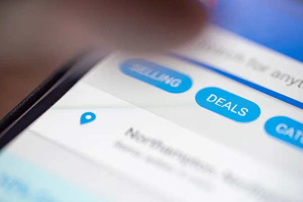 Pollice umano sul pulsante Offerte icona sullo shopping app sullo schermo dello smartphone primo piano — Foto Stock