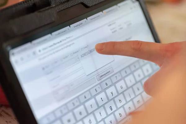 Imagem de close-up de mulheres mão segurando tablet preto e digitação na tela — Fotografia de Stock