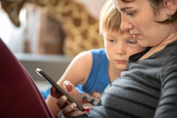 Mère et fils utilisant une tablette smartphone sur sofe à la maison — Photo