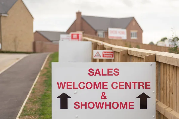 Sales welcome centre and showhome sign on new residential homes development estate entrance in England — Stock Photo, Image
