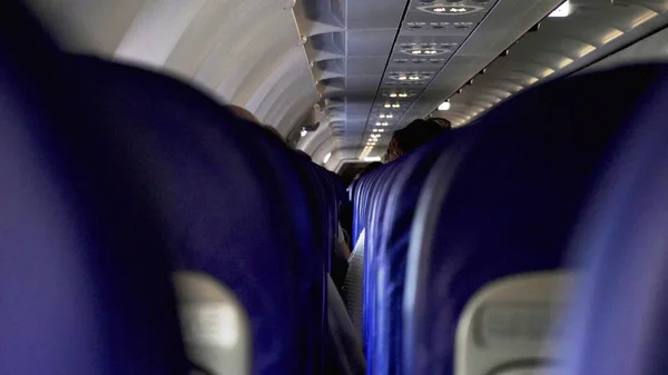 Candid disparo entre los asientos de los pasajeros sentados dentro del avión mientras viajan — Foto de Stock