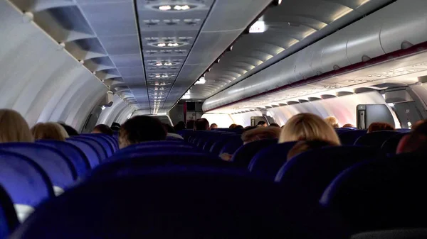Candid disparo entre los asientos de los pasajeros sentados dentro del avión mientras viajan — Foto de Stock