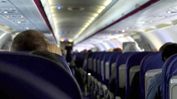 Cândido tiro entre assentos de passageiros sentados dentro do avião durante a viagem — Fotografia de Stock
