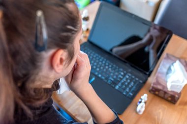 Laptop ilaçlar yanındaki evden çalışan genç hasta