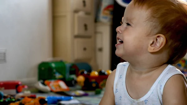 Opgewonden lachende babyjongen aanbrengen op de vloer thuis en tv kijken — Stockfoto