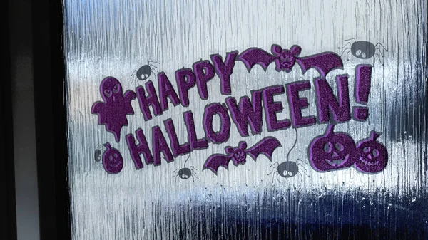 Motion shot of purple halloween sticker on clear stained door glass — Stock Photo, Image