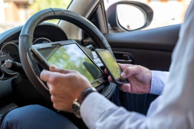 Tablet smartphone arabanın içine parlak gün çalışma ve iş adamı