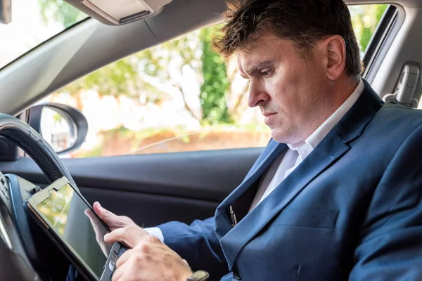 Empresario trabajando en la tableta dentro del coche en el día brillante — Foto de Stock