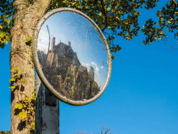 Gamla flyblown konvexa glas road safety spegel över träd med hus speglar i engelska byn — Stockfoto