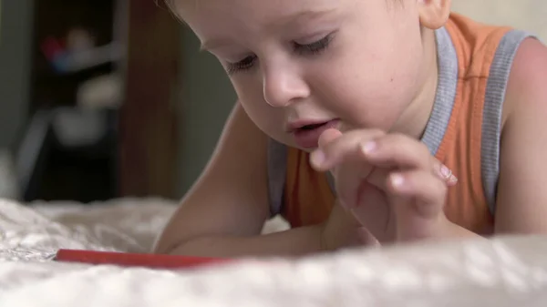 Kind jongen kijken smartphone spelen op bed thuis. afstandsonderwijs; — Stockfoto