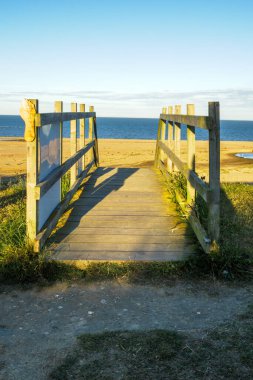Kumsaldaki tahta köprü yolu ve Lowestoft Suffolk 'taki kum tepeleri.