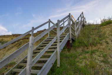 Sahile doğru inen ahşap merdivenler ve Lowestoft Suffolk 'taki kum tepeleri.