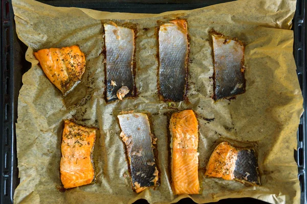Залишки шматочків шкіри лосося на паперовому лотку для випічки — стокове фото