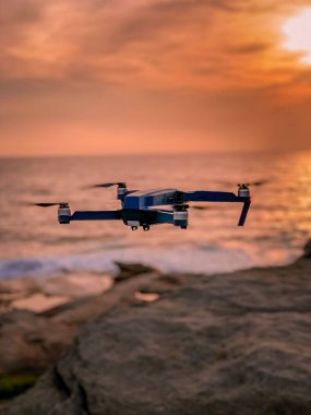 Günbatımında gökyüzünde bir dron. Dışarıdaki kuadrokopteri kapatın..