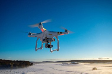 Gökyüzünde kamera olan uçan bir dron.