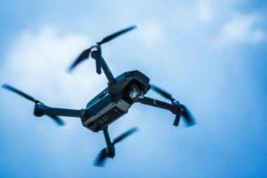 Gökyüzünde kamera olan uçan bir dron.
