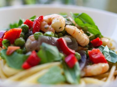 Yakın plan bir tabakta sebzeyle pişirilmiş iştah açıcı karidesler.