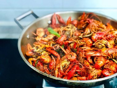 Yakın plan bir tabakta sebzeyle pişirilmiş iştah açıcı karidesler.