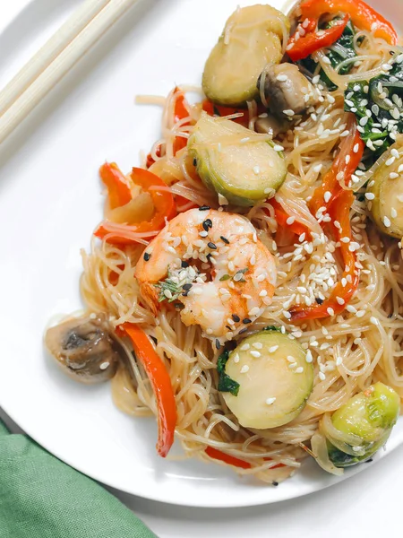 Tasty appetizing pasta with shrimps, vegetables served on plate.