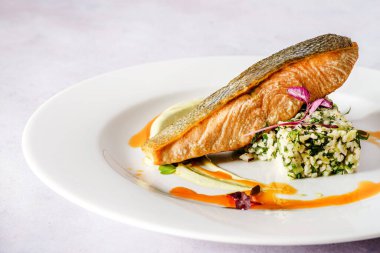 Patates ve sebzeli kızarmış somon bifteği.