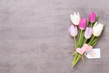 Bahar tebrik kartı, gri arka plan üzerinde pembe renk laleler.