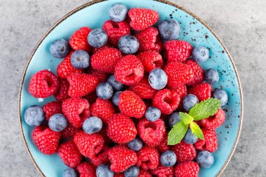 Vintage bir arka plan üzerine bir tabak içinde taze frambuaz. 