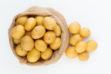 Ahşap arka planda taze çiğ patates çuvalı.