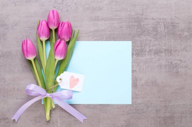 Bahar tebrik kartı, gri arka plan üzerinde pembe renk laleler.