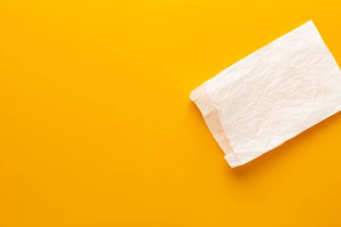 Sarı arka planda beyaz kese kağıdı.