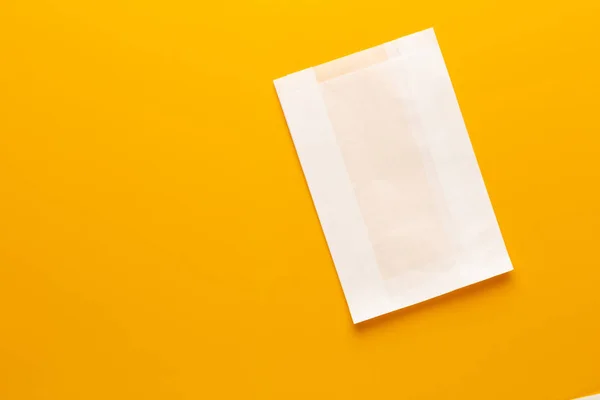 White paper bag on yellow background. — Stock Photo, Image