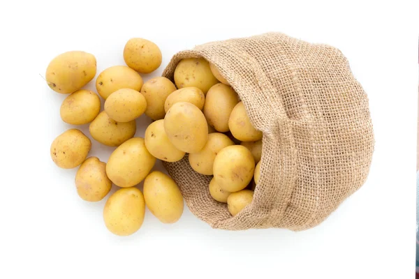 Sack of fresh raw potatoes on wooden background, top view — Stock Photo, Image