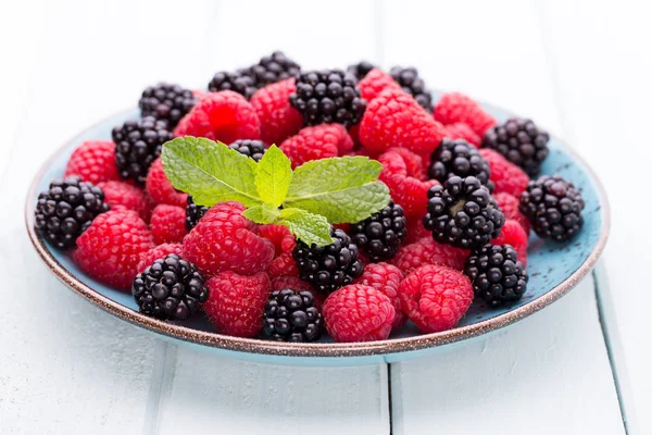 Fresh raspberries in a plate on a  vintage background. — Stock Photo, Image