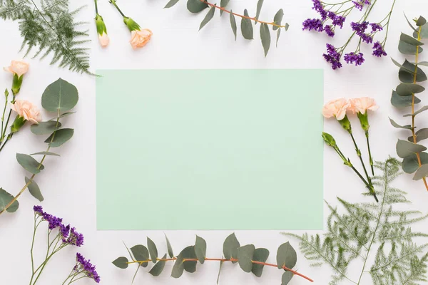 Composición de flores. Papel en blanco, flores de clavel, eucalipto — Foto de Stock