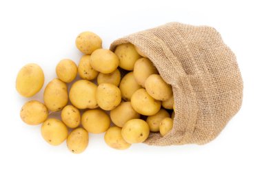 Ahşap arka planda taze çiğ patates çuvalı.