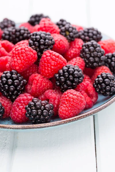 Fresh raspberries in a plate on a  vintage background. — Stock Photo, Image