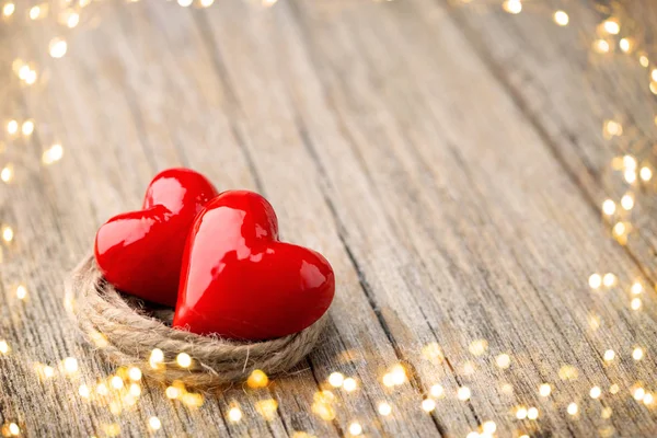 Dos rojo en forma de corazón sobre un fondo de madera . — Foto de Stock