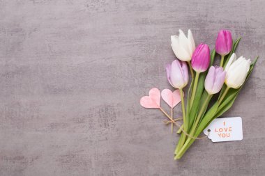 Bahar tebrik kartı, gri arka plan üzerinde pembe renk laleler.