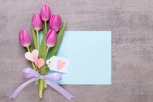 Frühling Grußkarte, rosa Farbe Tulpen auf dem grauen Hintergrund. — Stockfoto